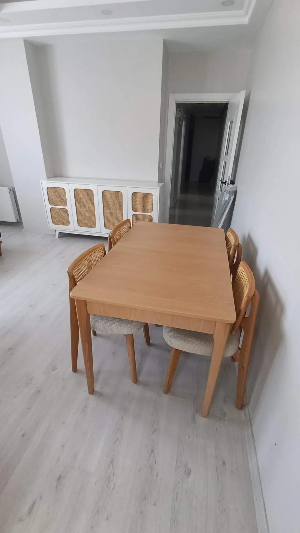 Müşteri evinde meşe renk açılır yemek masası ve hasır sırtlı sandalyeler