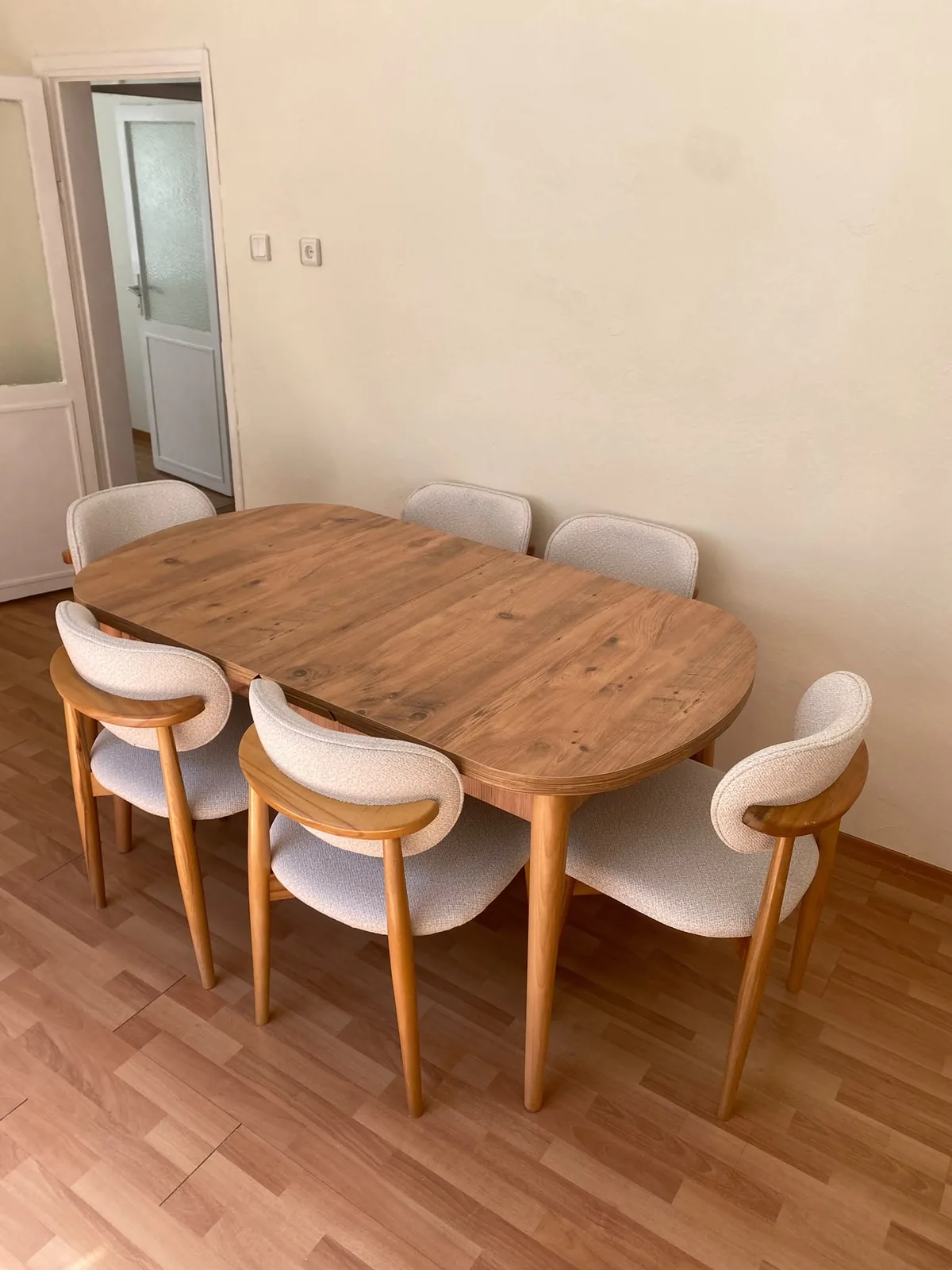 Müşteri evinde antik çam desenli oval açılır yemek masası ve altı krem bukle sandalye