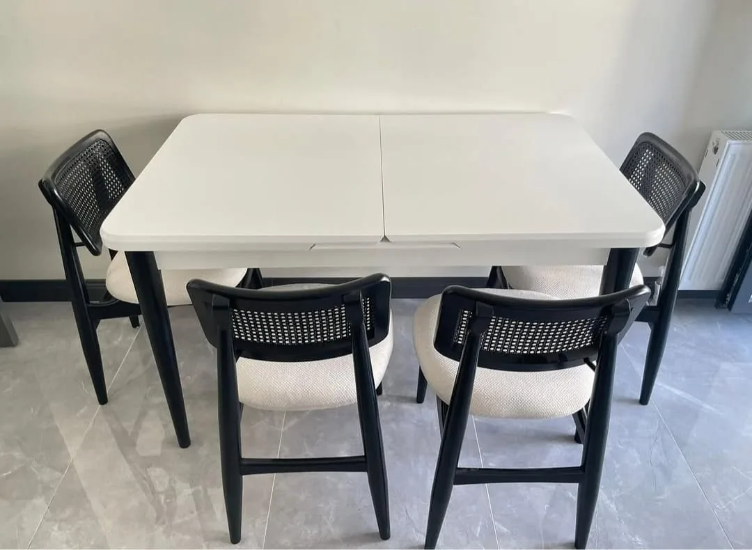 Krem renk açılır yemek masası ve dört siyah hasır sırtlı, krem döşemeli sandalye