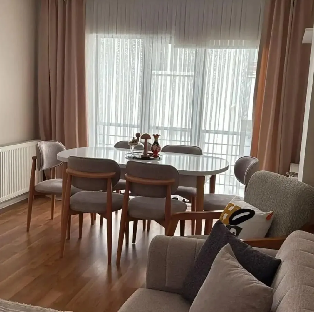 Müşteri evinde beyaz oval masa + 6 ahşap kollu sandalye