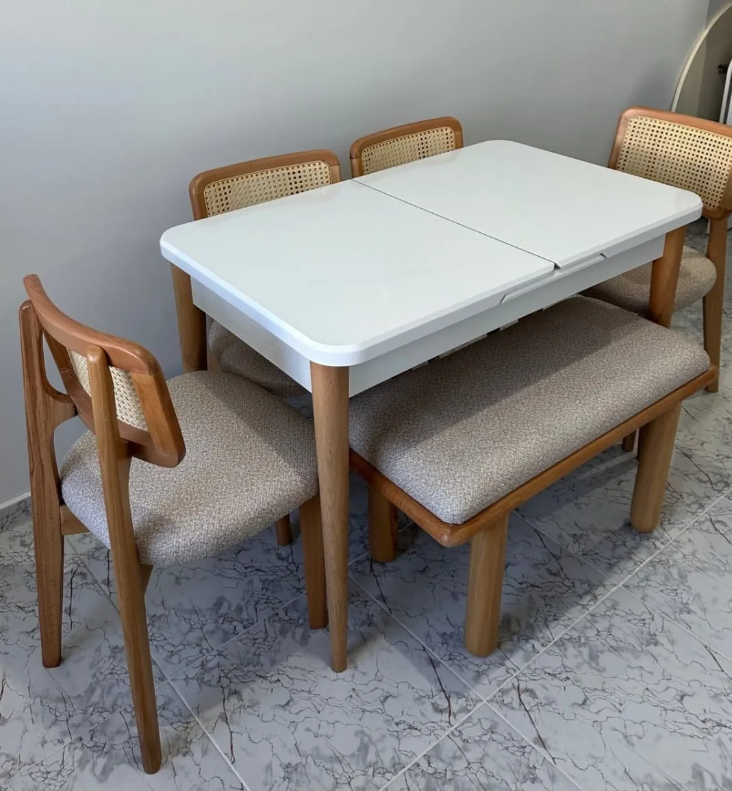 Beyaz açılır masa, hasır sırtlı ahşap sandalyeler ve bench